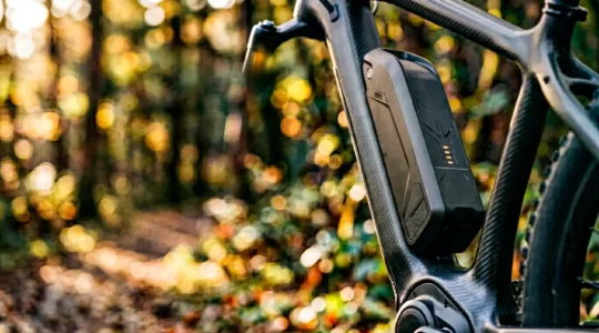 Batterie de vélo électrique intégrée au cadre avec indicateur de charge en environnement naturel