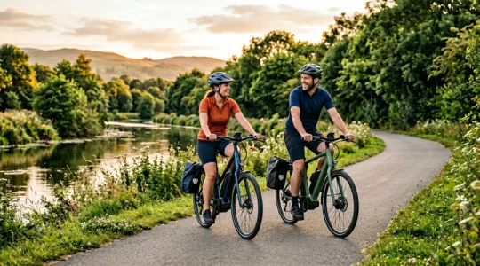 Couple faisant du vélo électrique sur un chemin de cyclotourisme bordé de nature