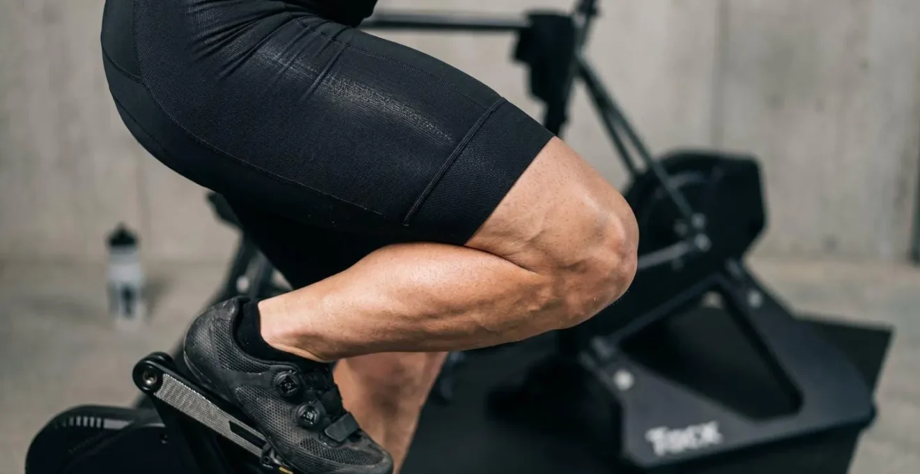 Cycliste s'entraînant sur home-trainer dans un espace intérieur minimaliste