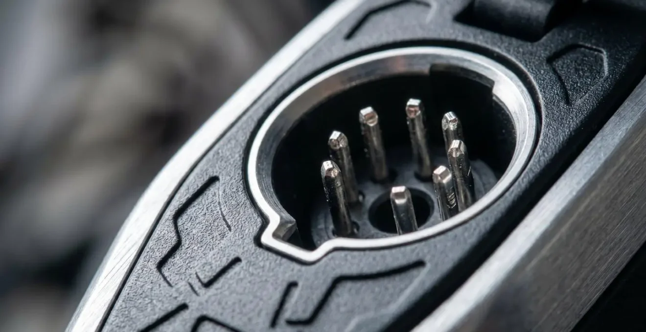 Gros plan macro sur connecteur de charge de batterie vélo électrique montrant détails des broches métalliques
