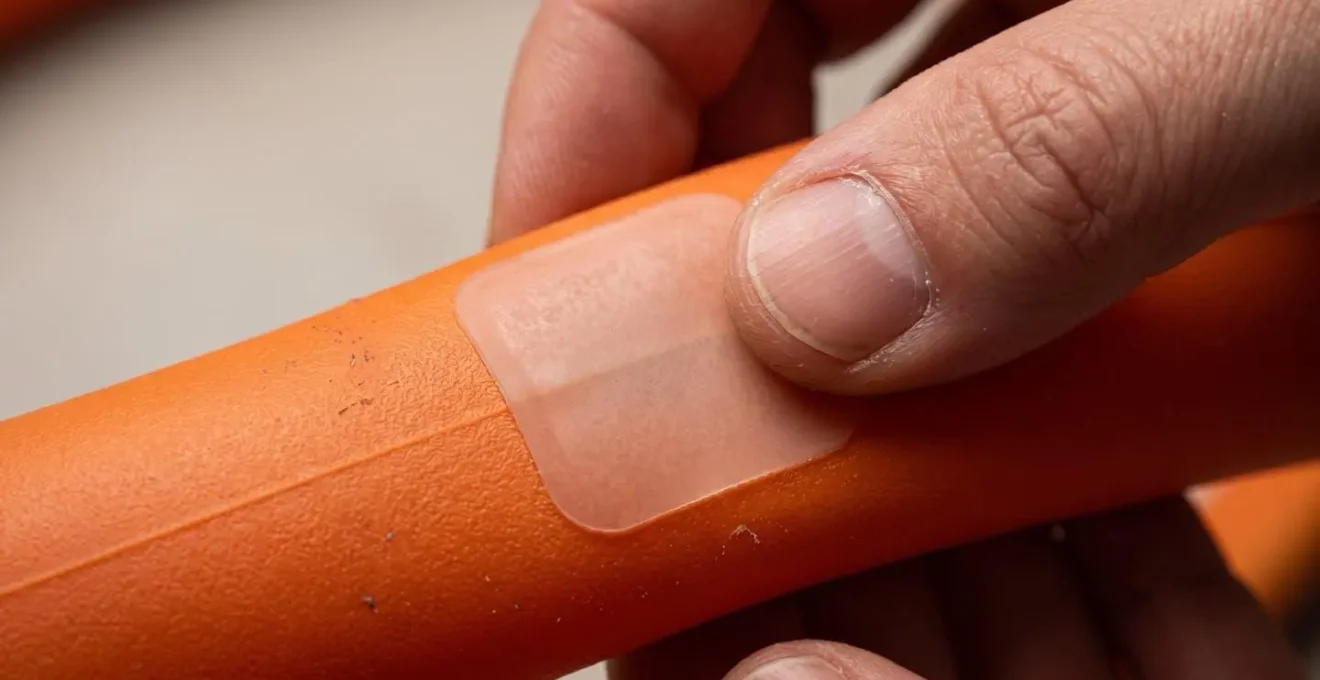 Gros plan sur le processus de réparation d'une chambre à air en TPU avec patch adhésif